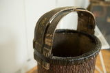 Worn black handle with gold script and dark woven rim of the Chinese willow basket.