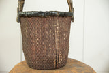 Aged Chinese willow basket, dark woven texture, vertical seam, and bottom fraying.