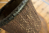 Distinct dark brown textured weave and smooth black top rim of the willow basket.