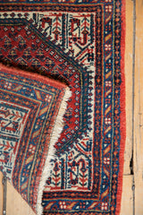 Hand-knotted Mir Sarouk rug corner folded, revealing fringe and intricate cranberry, indigo borders.