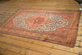 Vintage Farahan Sarouk rug featuring an oversized madder red medallion, surrounded by tangerine floral vinery on ivory.