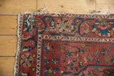 Antique Mission Malayer rug corner: madder red field, navy border, tattered ivory fringe.