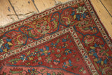 Antique Mission Malayer rug corner, displaying madder red field, vibrant abrashes, visible wear, tattered fringe.