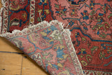 Antique Malayer rug corner folded to reveal abrash-rich pile, tattered fringe, and hand-knotted foundation.