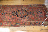 Rich madder root red field with abrash, deep navy medallion, and wear on antique Malayer rug.