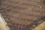 Corner of antique Caucasian fragment rug, geometric lattice pattern, brick red, blue, and tattered.