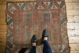 Antique Caucasian rug's central avar medallion, crab motifs, aged brick red, cobalt blue.