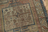 Antique Caucasian rug with rectilinear motif, serrated border, and visible, storied wear.