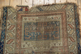 Storied tatter and repair patch on the worn top edge of an antique Caucasian runner.