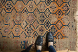 Antique Caucasian rug, unusual tangerine, blue, beige multi-medallion pattern, threadbare texture, with feet.