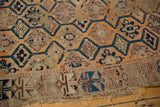 Antique Caucasian fragment's tattered geometric border with worn blue, brick red, and tangerine motifs.