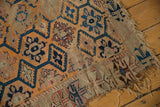 Antique Caucasian rug: tattered edge, threadbare multi-medallion pattern in blue, orange, and red.