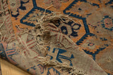 Threadbare antique Caucasian rug detail with tattered edges and exposed beige, blue, and orange foundation.