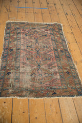 Upper left corner detail of the antique Lilihan rug, showing faded brick red and indigo blue vinery.