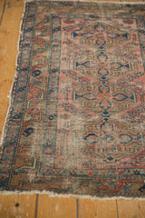Aged indigo blue border and faded brick red field with delicate vinery on an antique Persian Lilihan rug.