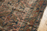 Antique Lilihan rug's detailed border shows vinery, faded brick, indigo tones, and edge tatter.