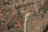 Folded corner of Antique Lilihan rug, showing tattered fringe, overcast edge, and foundation weave.