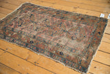 Close-up of the antique Lilihan rug's tattered overcast edges and faded floral border.