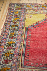 Saffron yellow and cherry red repeating boteh motifs on the Melas rug border.