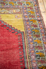 Vintage Melas rug detail, repeating boteh borders and stepped Ladik panel in red and saffron yellow.