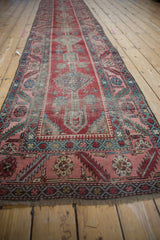 Angled perspective of an antique Karabagh runner featuring its central medallions and blush rose border.