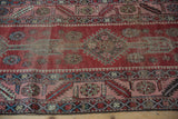 Detailed view of the low pile and etched geometric patterns on a cherry red antique Karabagh rug.