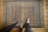 Antique Belouch rug, geometric pattern, muted indigo, madder, and ivory, with mostly even wear.