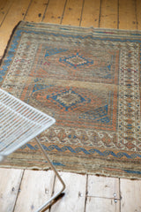 Antique Belouch rug corner with worn plainweave and indigo blue, madder red geometric motifs.