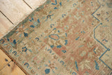 Antique Farahan Sarouk rug: faded floral pile detail in sand, blue, brick red. Shows wear, tattered fringe.