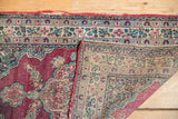 Folded corner of the antique Kerman rug revealing its detailed hand-knotted foundation and weave.