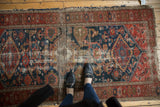 Worn central Harshang design on an antique Malayer rug in cochineal red and indigo.