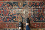 Antique Malayer rug displaying worn central Harshang design and hand-knotted foundation.