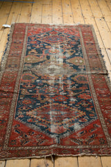 Antique Persian Malayer rug detail: cochineal red border, indigo field, time-softened Harshang motif.