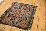 Vintage Hamadan rug's side with traditional interlaced border, tattered fringe, and pile wear.