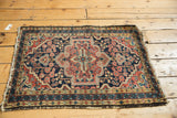 Vintage Hamadan rug corner, navy blue medallion, pale brick red floral field, scrolling border, tattered fringe.