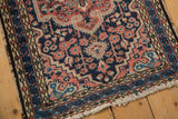 Vintage Hamadan rug corner, with navy blue field, scrolling border, floral motifs, and tattered fringe.