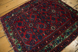 A collector's antique Hamadan rug showing the dense Herati pattern and unusual green border.