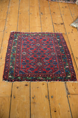 Angled view of the entire antique Hamadan mat, showing its rich red and green colors.