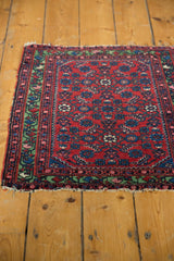 Corner view of a fine Hamadan rug showing its brilliant green border and hand-knotted end.