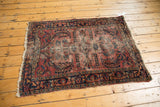 Vintage Lilihan rug's worn side edge and intricate navy floral border.