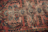 Vintage Lilihan rug's dusty raspberry field, navy floral vinery, and visible low pile.