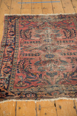 Vintage Lilihan rug's dusty raspberry field, sprawling navy floral vinery, low pile.