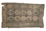 Antique Fragment Caucasian rug with double column medallions, geometric border, and visible patina.