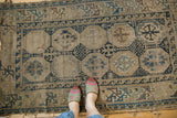 Detail of Antique Caucasian rug with ivory, navy, sky blue geometric motifs and wear.
