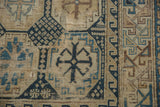 Antique Caucasian rug detail: geometric shapes, cross-views in navy, sky blue, beige.