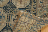 Corner detail of antique Caucasian fragment rug showing hard tatter, frayed fringe, and geometric motifs.