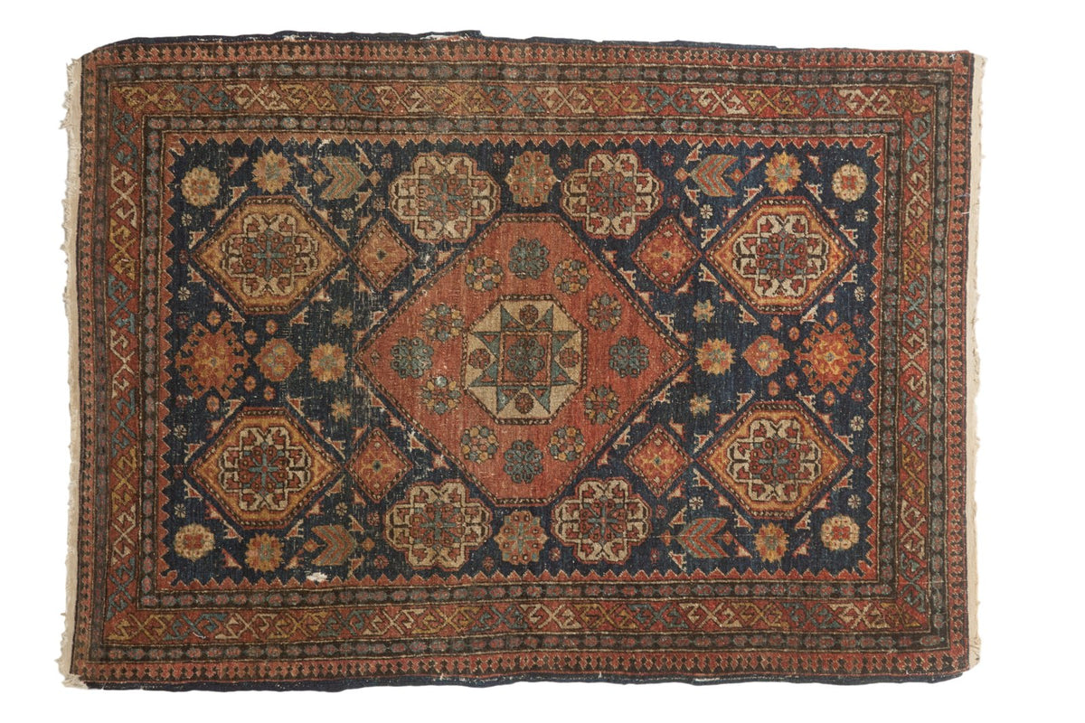 Antique Tehran rug with a large madder red medallion on a dark indigo blue field with saffron floral accents.
