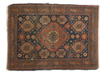 Antique Tehran rug with a large madder red medallion on a dark indigo blue field with saffron floral accents.