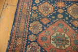 Corner detail of an antique Tehran rug highlighting the worn pile and intricate borders.