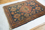 Slightly tattered side and corner of the antique Tehran rug with its intricate geometric border.